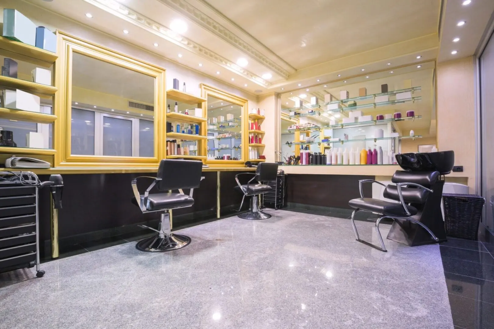 A hair salon with chairs and mirrors in the room.